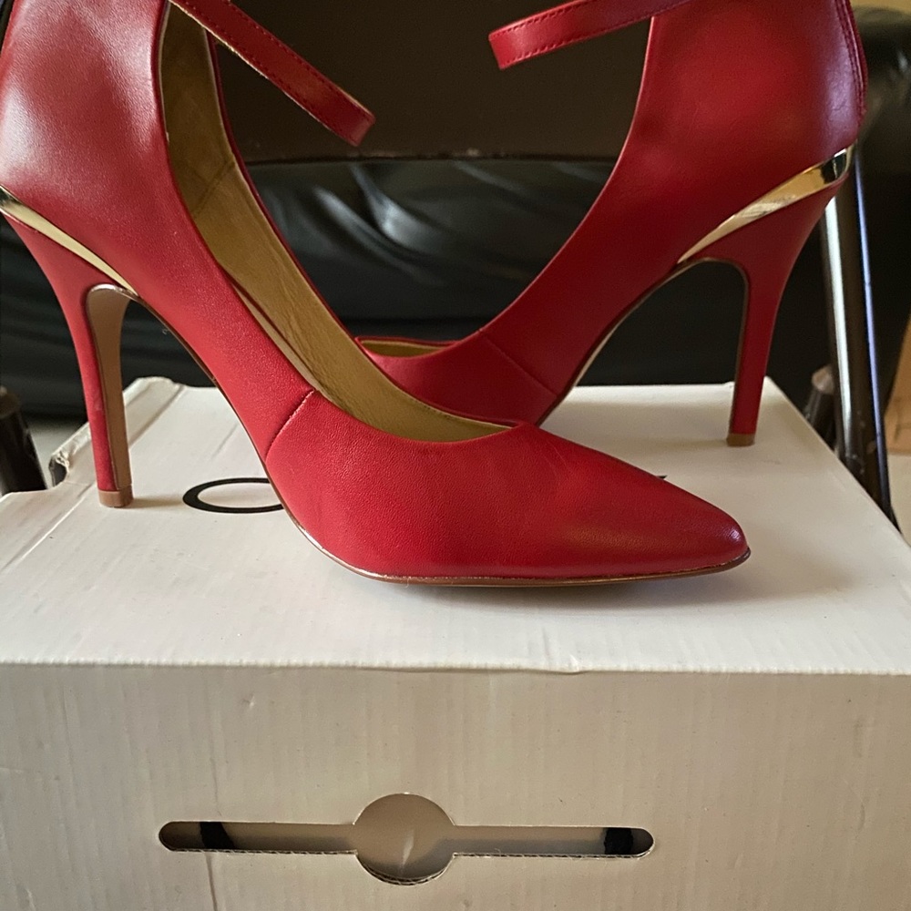Red women’s strap heels with gold zipper in back.